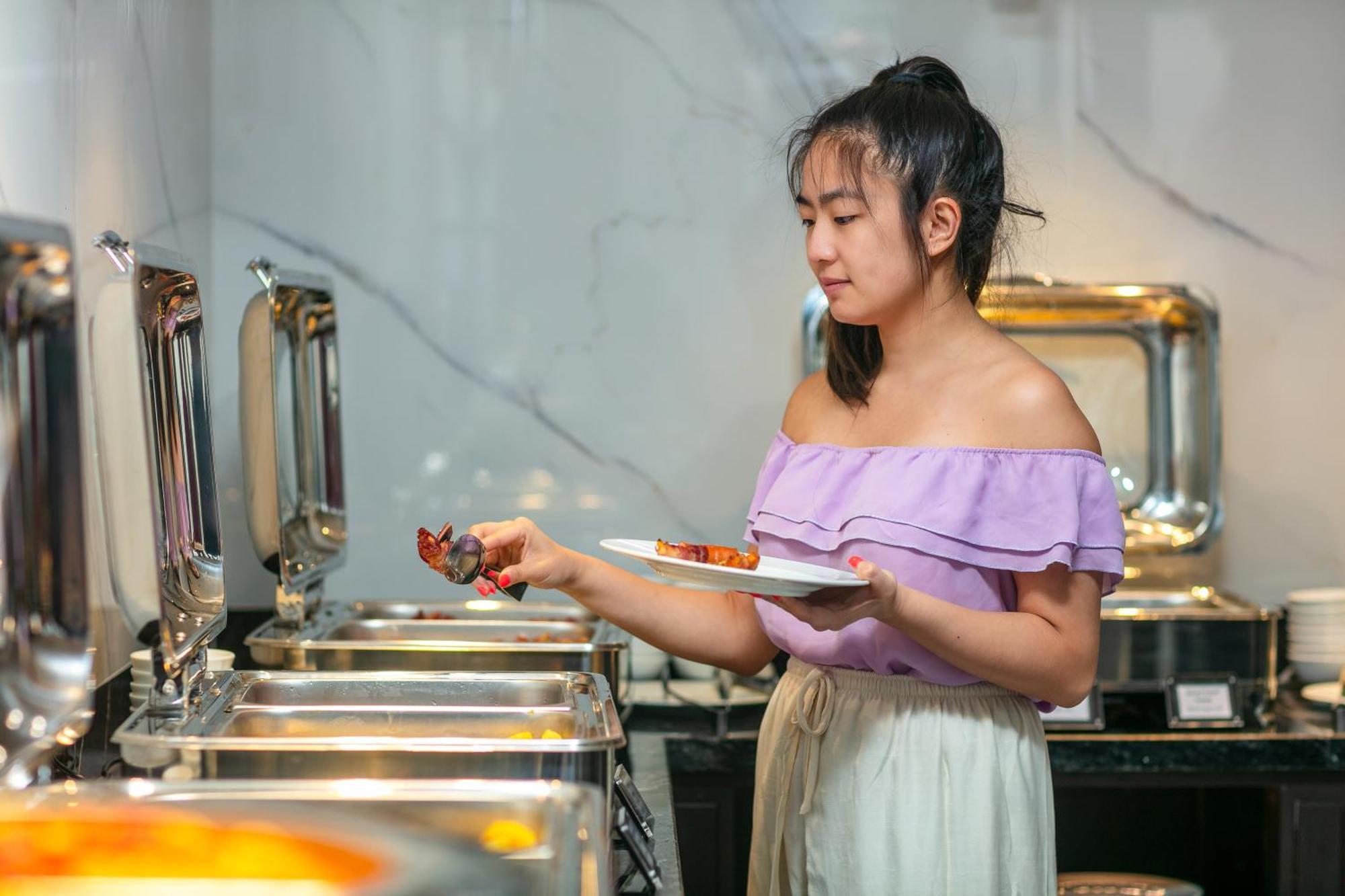 May De Ville Lakeside Hotel Hanoi Exterior foto A woman serving herself at a buffet